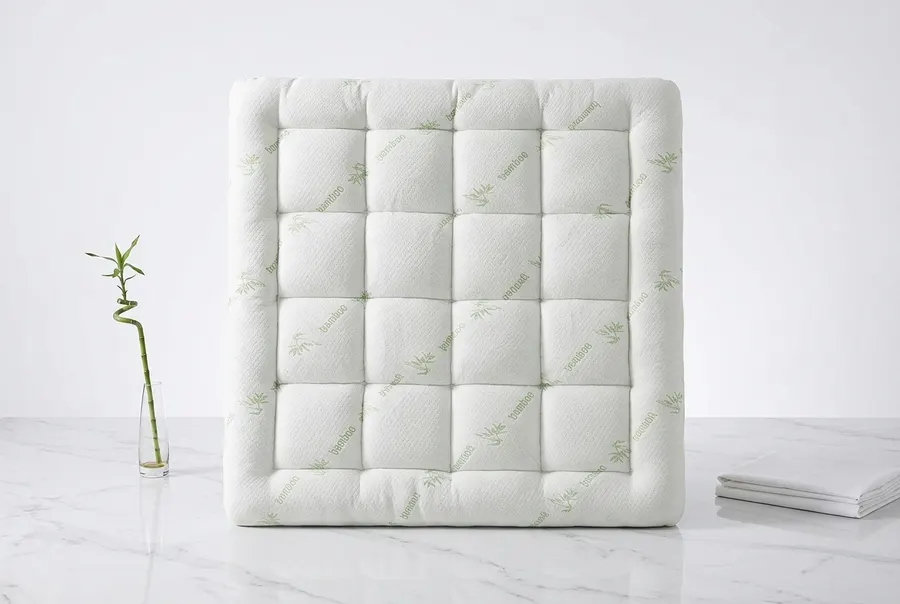 A thick organic bamboo mattress topper centered on a wooden bed frame in a bright airy bedroom, photographed from a three-...