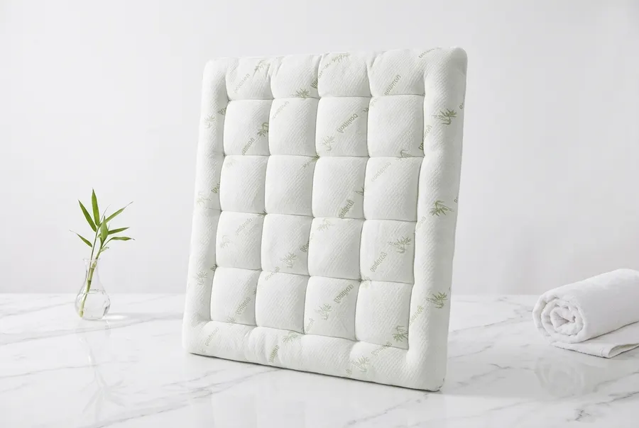A plush organic bamboo mattress topper laid flat on a queen-size bed, surface smooth and level, deep fitted stretch skirt ...