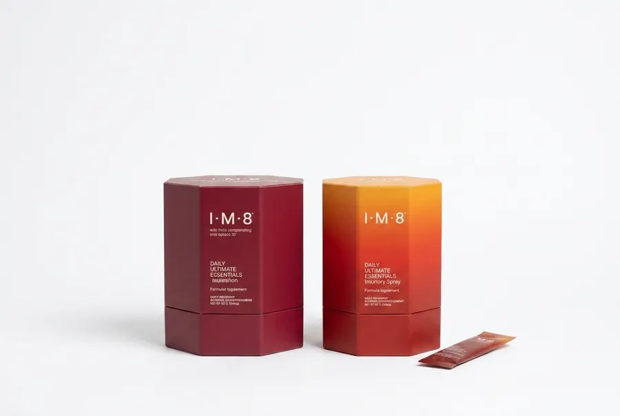 photograph of IM8 Health in a real in-use moment — the product placed or held prominently in a warm, authentic everyday se...