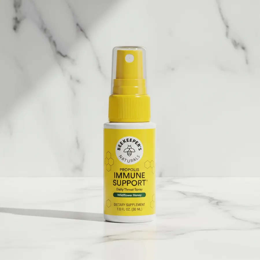 A slim, elegant throat spray bottle of propolis extract positioned on a clean bathroom or kitchen shelf alongside fresh wi...