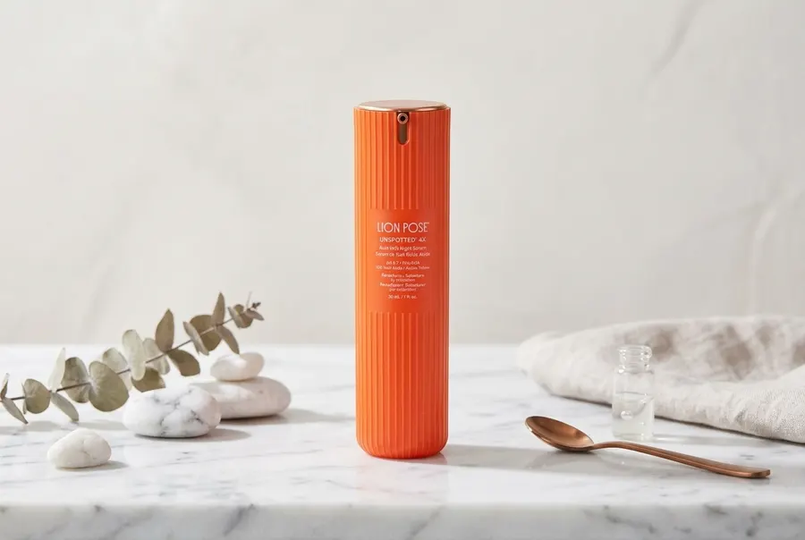 Three minimalist glass bottles of a dermatologist-formulated acid blend arranged on a clean marble bathroom shelf in soft ...