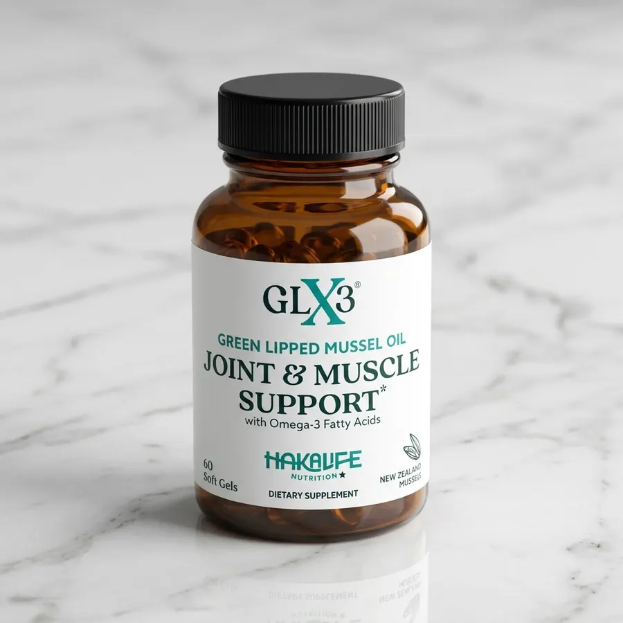A frosted glass softgel capsule of green-lipped mussel oil resting on a smooth stone beside a single open green-lipped mus...