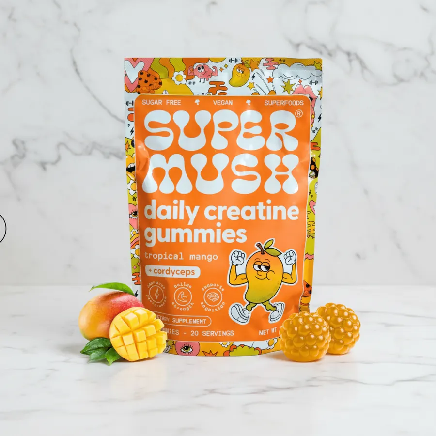 A fit athlete in modern athletic wear holding a handful of colorful creatine gummies with a satisfied smile, bright natura...