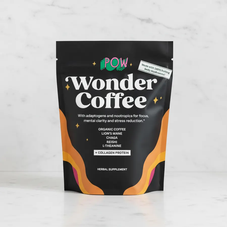 Flat-lay overhead of Wonder Coffee packet or cup surrounded by loose mushroom pieces, coffee beans, and botanical elements...