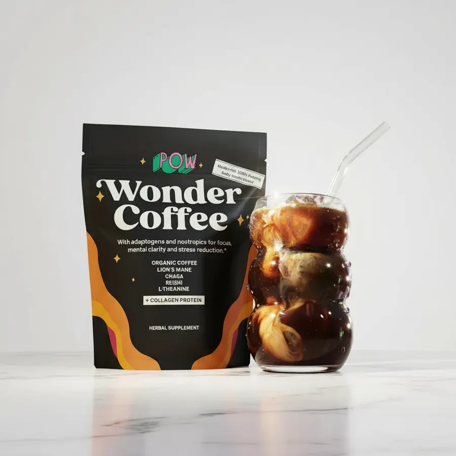A mom in her home kitchen pouring a rich, dark functional coffee blend from a slim, matte pouch of specialty coffee into a...