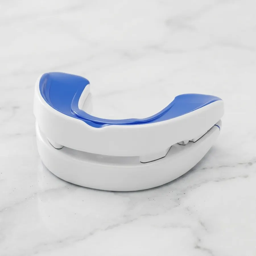 A studio product shot of an adjustable anti-snoring mouthpiece (thermoplastic mandibular advancement guard with visible Ac...