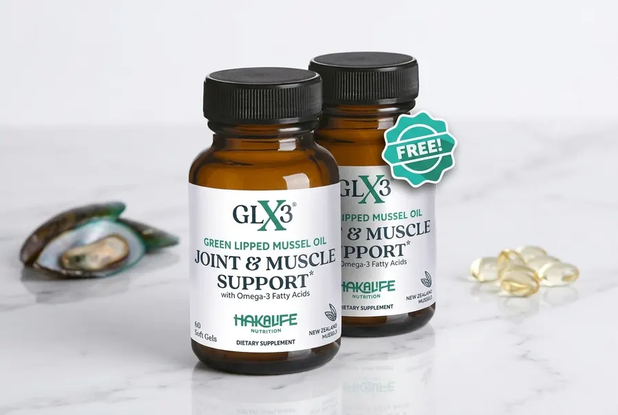 A frosted dark green glass bottle of green lipped mussel oil supplement standing upright on white marble, beside a small p...