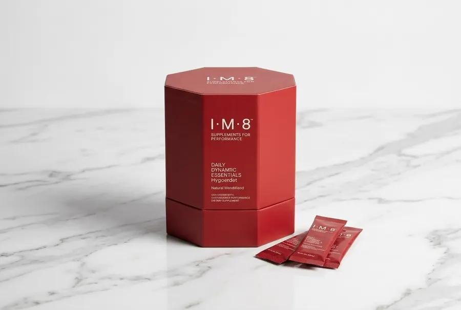 A frosted glass of daily supplement drink on a clean kitchen counter next to a single coffee mug, bright indirect morning ...