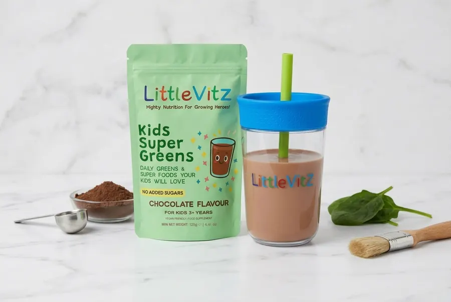 A matte white pouch of superfood greens powder for children centered upright on a seamless two-tone backdrop, one panel so...