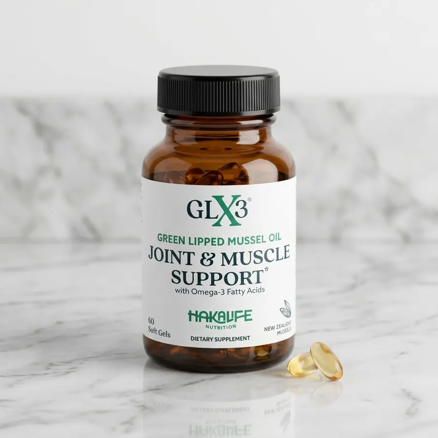 A frosted glass bottle of green-lipped mussel oil softgels on a clean white marble counter beside a small bowl of fresh mu...