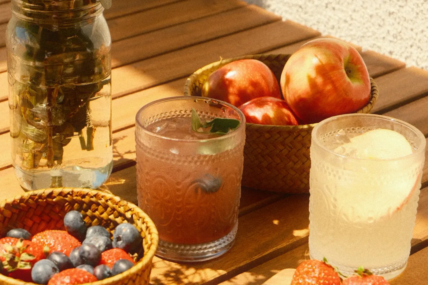 A slim can of mineral-infused sparkling water on a sunlit wooden kitchen counter next to a halved fresh coconut and a smal...