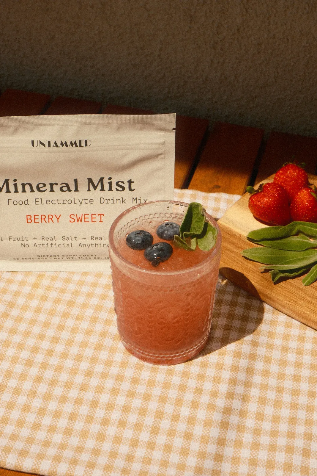 A single stick packet of mineral electrolyte powder upright and centered on a clean white marble surface, occupying 60% of...